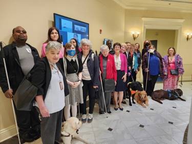 NFBMD members stand with sponsor Delegate Mary Lehman at House Guide Dog Protections in Housing bill hearing