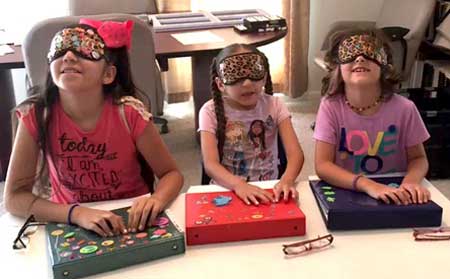 shows three girls wearing sleep shades gluing decorations on their binders.