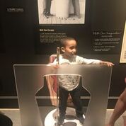shows a boy examining part of a museum exhibit.
