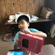 shows a boy decorating his box.