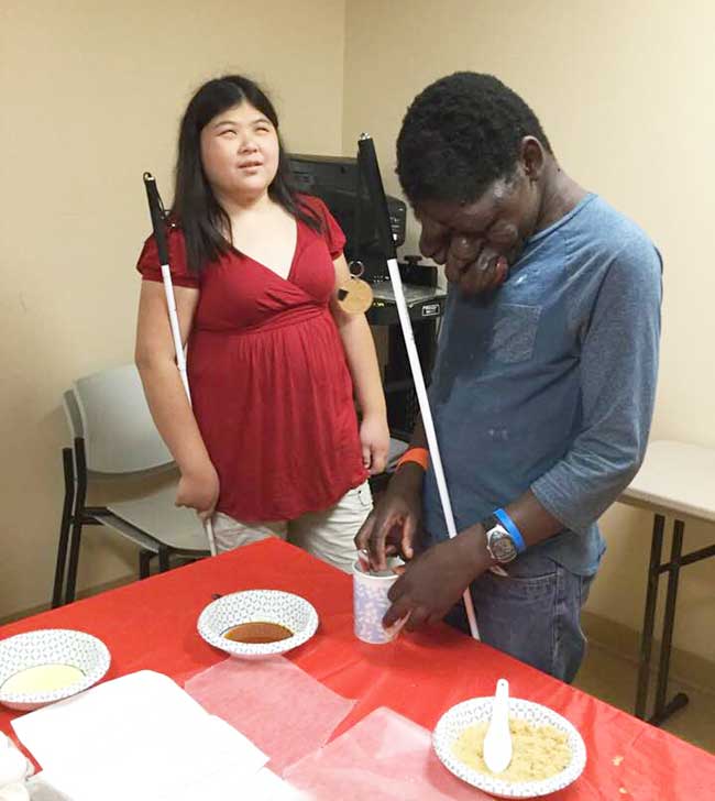 shows BELL volunteer teaching blind student to measure ingredients for cookies.